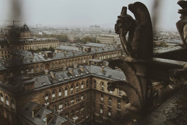 Gargoyles overlooking a rainy cityscape with text that reads, "The Power of Letting Go"
